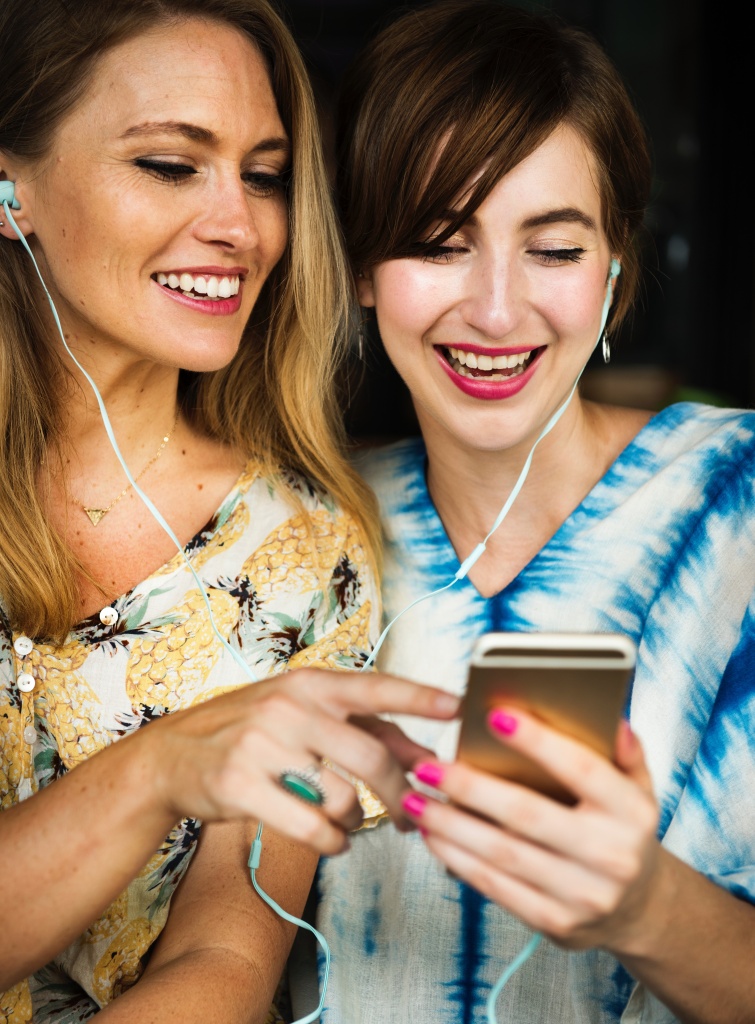 Two young ladies laughing at YouTube videos