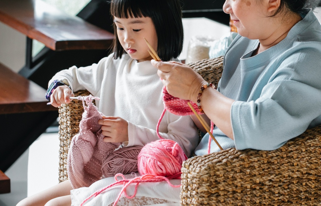 A little girl kniting with her grandma