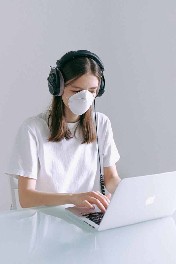A girl with face mask using a computer