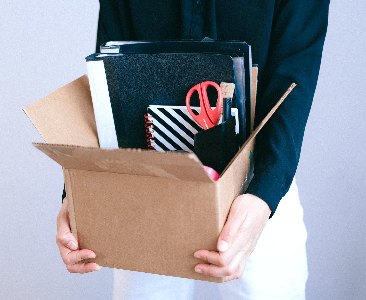 Lady holding box of office supplies